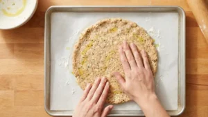 Can Chicken Pizza Crust Recipe: The Viral Low-Carb Pizza Americans Are Loving 5 Shaping chicken pizza crust mixture into a round crust on parchment paper
