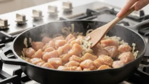 Chicken browning in skillet for baked turbriskafil.