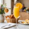 Classic mimosa recipe in a champagne flute with fresh orange juice and sparkling wine on a brunch table