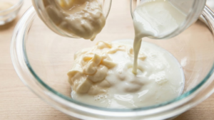 Mayonnaise and buttermilk being added to a bowl
